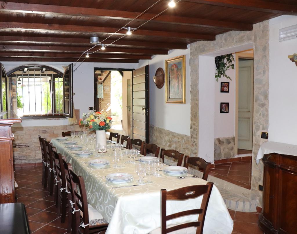 Main dining room of Villa Ruffini showing exposed wooden beams, stone walls, and traditional furnishing
